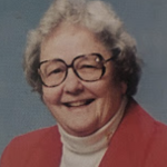 Woman smiling, wearing glasses